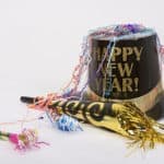 Happy New Year top hat surrounded by party favors.